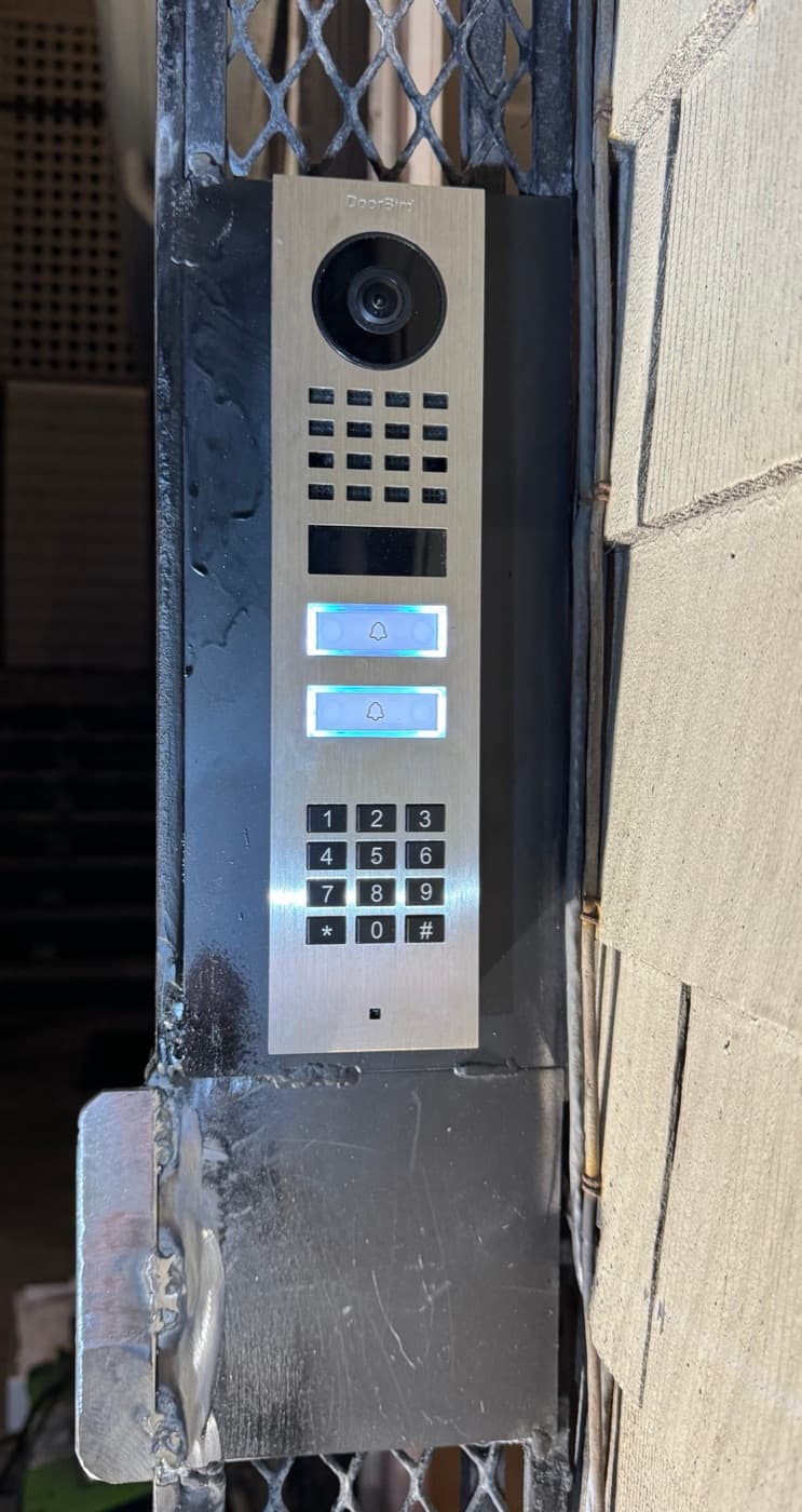 Video intercom with keypad mounted on a mesh security gate with a welded plate