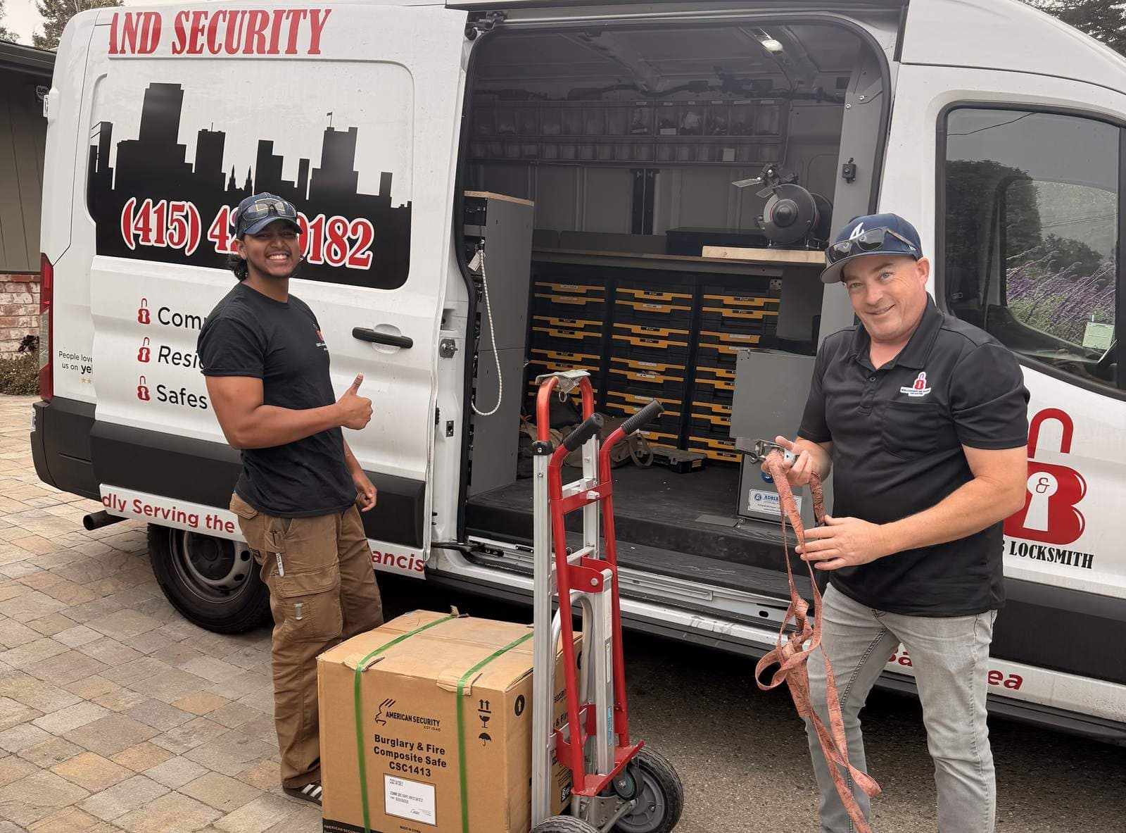 Two B&B technicians with the company van and an American Security burglary and fire safe on a hand truck, ready for delivery