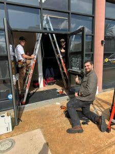 B&B security technicians install an electrification kit on a set of business entry doors for a Bay Area commercial property